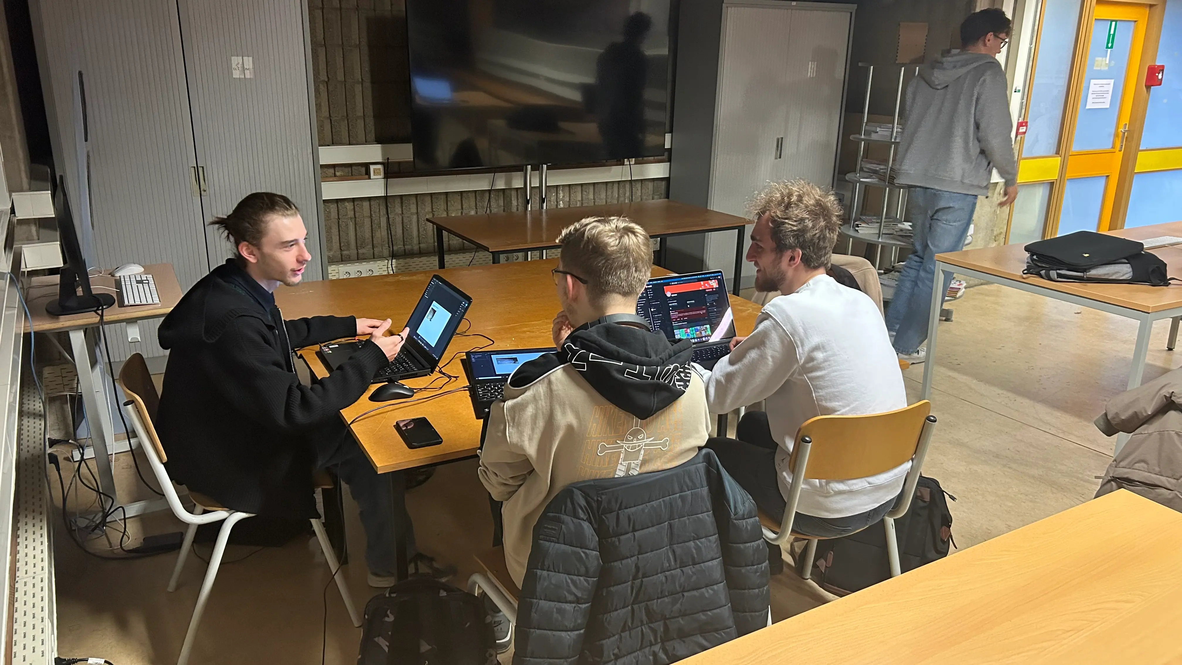 Un groupe de trois personnes en train de travailler devant leurs ordinateurs respectifs